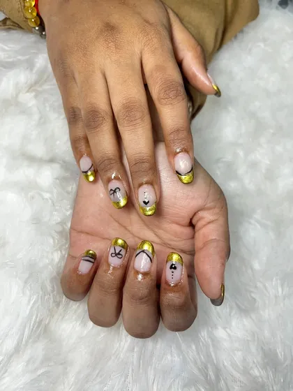 This angle shows the different designs on each nail, all tied together with the beautiful gold chrome French tip. It's a great way to have a cohesive yet varied look.