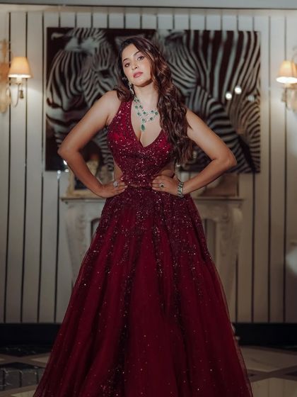 A full view of this stunning red gown, perfect for a Sangeet or reception. The makeup is kept glamorous and glowing to match the drama of the outfit, ensuring she is the star of the show.