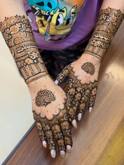 A beautiful half-sleeve design featuring delicate peacock motifs on the palms.