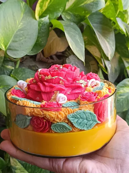 My rose garden jar candle is a vibrant and intricate piece. It features a large central rose surrounded by smaller roses and leaves, with gold leaf accents, all within a large glass jar.