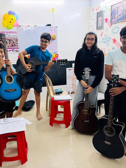The joy of learning together. Our guitar students, with a mix of acoustic and semi-acoustic guitars, pose for a happy picture during a break in their group class.