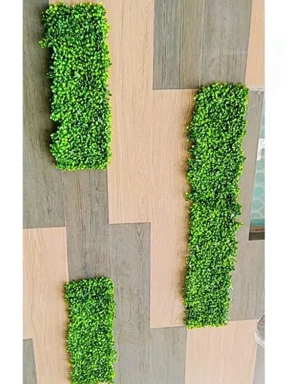 We often use geometric patterns in our designs. Here, rectangular panels of artificial greenery are arranged to create a modern, artistic installation on a tiled exterior.