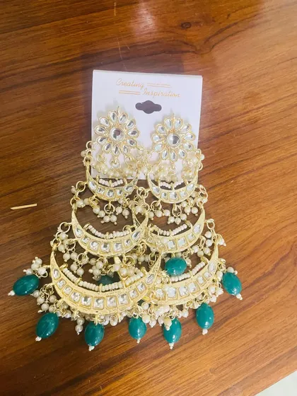 These tiered chandbalis are a wedding season favorite. This pair in green is designed to be grand and eye-catching, making them perfect for brides, bridesmaids, or any guest who wants to stand out.