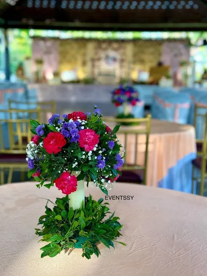 A floral centerpiece for one of the guest tables at the naming ceremony. Using consistent floral arrangements throughout the venue ensures a cohesive and elegant look for the entire event.