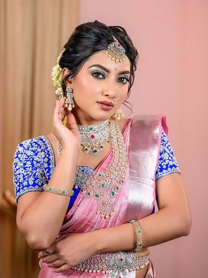 A stunning South Indian bride in a classic pink Kanjeevaram saree with diamond jewelry. This look showcases the flawless base and intricate eye makeup required for traditional ceremonies.