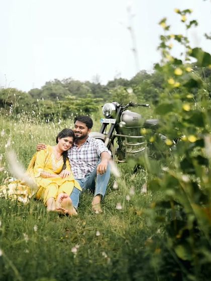 A dreamy, soft-focus shot of a couple relaxing in a field, creating a romantic and peaceful pre-wedding memory.