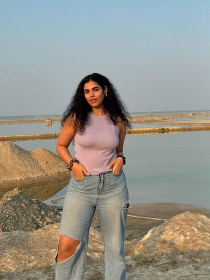 Lilac is my color. A shot of me at Sambhar Salt Lake in Rajasthan, wearing a simple lilac tank top and ripped jeans. The stark, beautiful landscape is a unique backdrop.