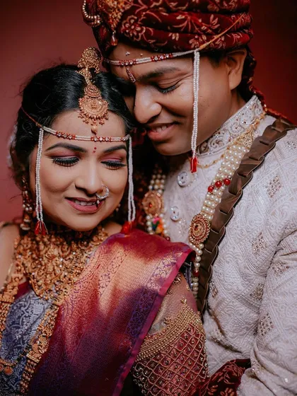 An intimate portrait of the couple during their wedding ceremony. The warm lighting and their close embrace create a beautiful, romantic mood.