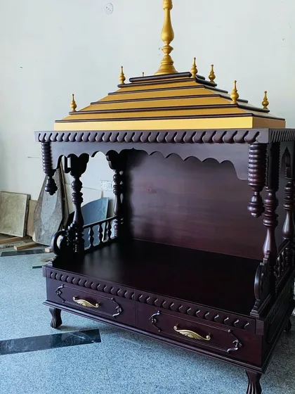A home's spiritual center deserves to be a work of art. This handcrafted wooden mandir, with its traditional silhouette, intricate carvings, and gilded accents, is a signature piece that brings a sense of peace and heritage into the home.