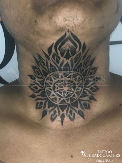 A large mandala tattoo on the throat, a bold and spiritual piece that symbolizes the universe.