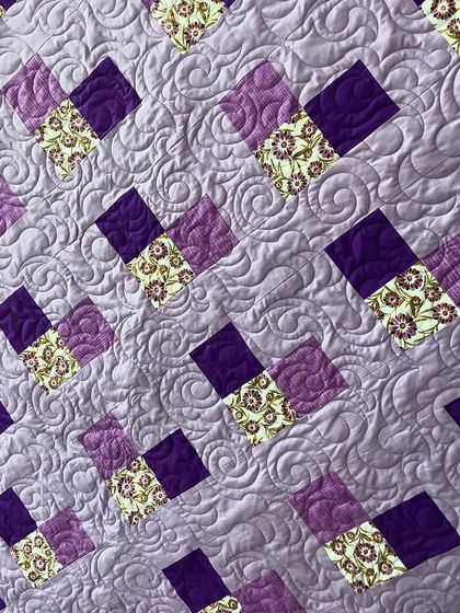 A detail shot of the purple quilt, showing the swirling all-over quilting pattern.