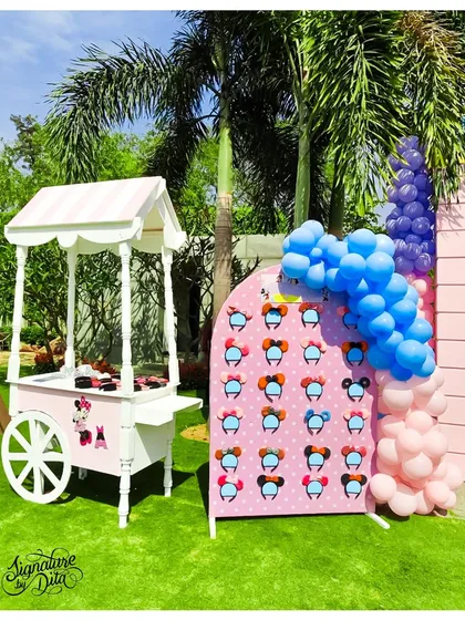 A Minnie Mouse-themed cart and a display wall for Mickey Mouse ears. These interactive stations allow kids to pick their own accessories and become part of the Disney magic.
