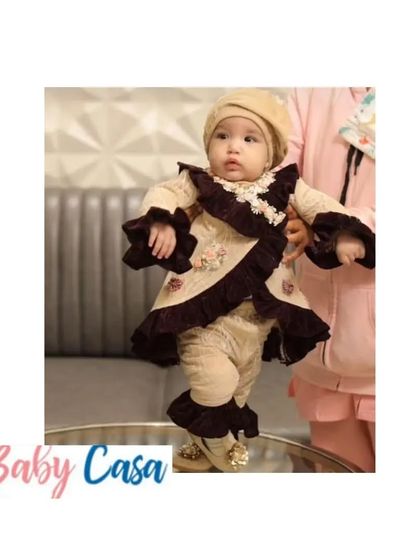 A chic and stylish outfit for a baby's first Lohri. This beige and brown velvet set with ruffle details is a modern take on traditional festive wear.