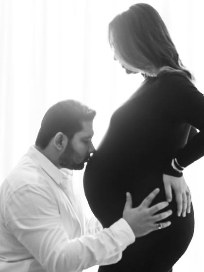 A father's gentle kiss for his unborn baby. This black and white photo is filled with so much love and emotion.