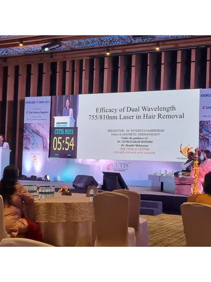 My practice is built on evidence-based medicine. Here I am presenting my research paper on the efficacy of dual-wavelength lasers for hair removal at a national dermatology conference, contributing to the shared knowledge of my field.