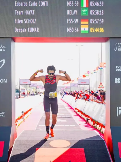 Crossing the finish line with his time displayed on the board. This image captures the proud moment of our athlete completing the Ironman 70.3 Middle East Championship.