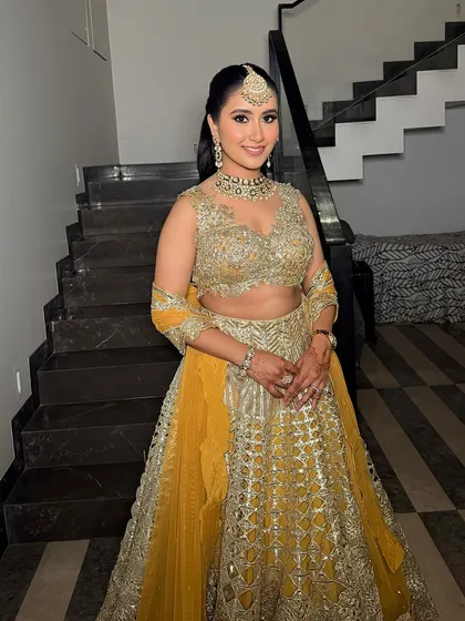 A full view of Garima's gorgeous yellow and gold lehenga, complemented by her stunning smokey eye makeup.