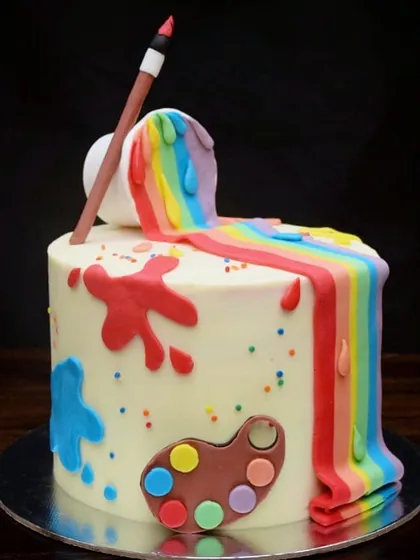 I created this fun artist-themed cake for a creative soul. It features a rainbow waterfall of fondant paint spilling from a bucket, paint splatters, and a little artist's palette, with vibrant rainbow layers hidden inside.
