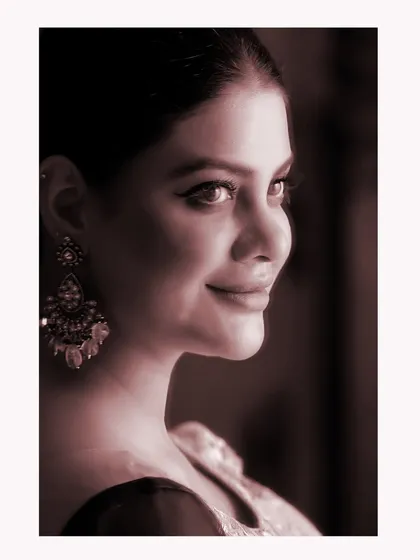 A soft, sepia-toned close-up of Sherleen Dutt. This artistic choice gives the portrait a nostalgic and timeless quality.