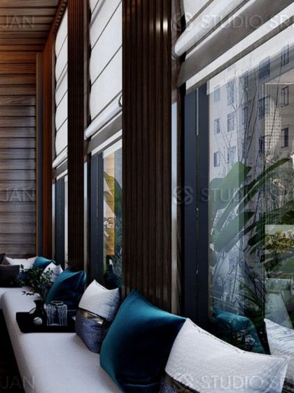 A long, built-in window seat provides ample seating and a place to enjoy the view, with elegant Roman blinds for privacy.