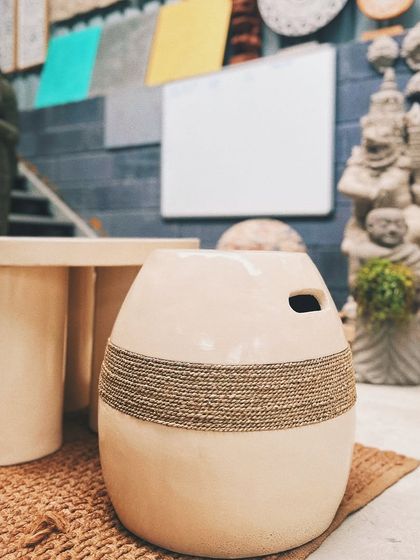 A closer look at our minimal outdoor stool. The simple, curved shape is accented with a band of natural rope, adding a touch of warmth and texture to the clean, modern design.