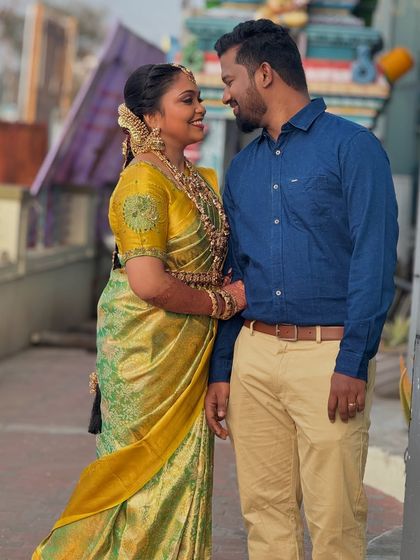 A candid shot of the couple in a traditional setting. Prithivi's makeup looks natural and radiant, fitting the authentic atmosphere of the moment.