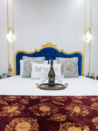 Inspired by Regency-era elegance, this master bedroom features a bold, royal blue tufted headboard set against a classic white and gold backdrop. It’s a testament to how we can infuse personality and a touch of royal glamour into any space.