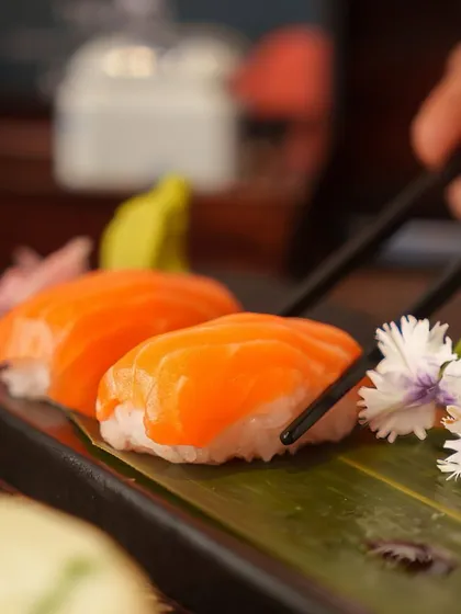 A close-up of our Salmon Nigiri, adorned with a delicate edible flower. The presentation reflects our attention to detail and our desire to create a beautiful dining experience.