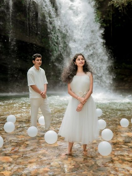 A creative composition with the couple in the foreground and background, surrounded by white balloons in the water.