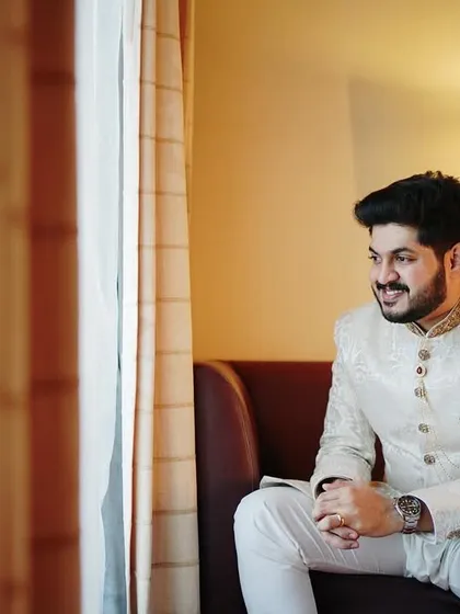 A contemplative portrait of the groom looking out the window. The soft light and relaxed pose create a thoughtful and cinematic moment.