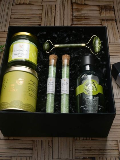 The 'Relax & Recharge' hamper is a spa day in a box. It features a lemongrass scented candle, jade roller, bath salts, and shower gel for the ultimate self-care experience.