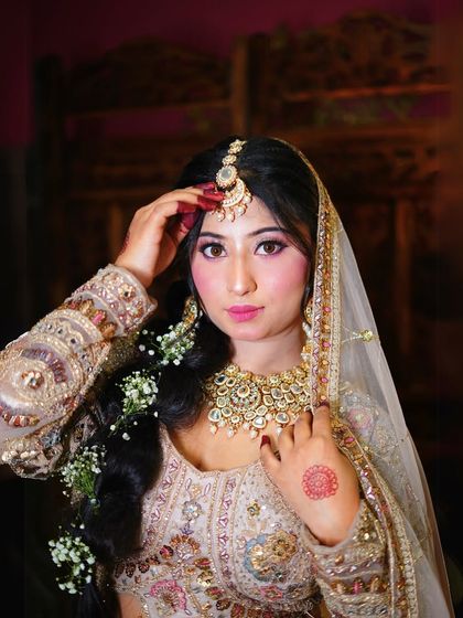 A close-up of the bridal makeup and jewellery. The long braid with flowers adds a beautiful, traditional touch.