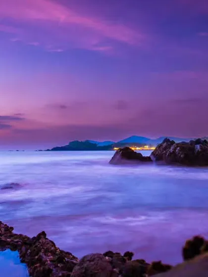 Another angle of the magical "aurora vibes" sunset in Goa. The long exposure technique smooths the water, enhancing the vibrant purple and pink colors in the sky.