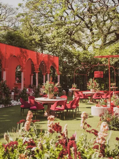 A wide view of the 'Gulal Bagh' setup, showing how the bold red structures and furniture create a cohesive and powerful design statement.