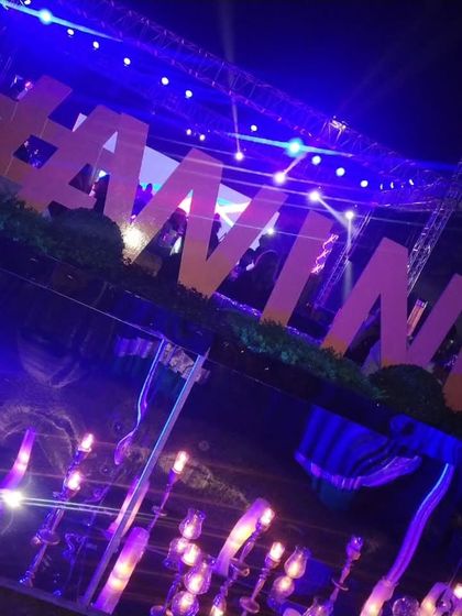 For a dedicated wine station, I used large, illuminated lettering and purple ambient lighting. The mirrored surface of the counter reflects the lights, enhancing the vibrant and sophisticated mood of the event.