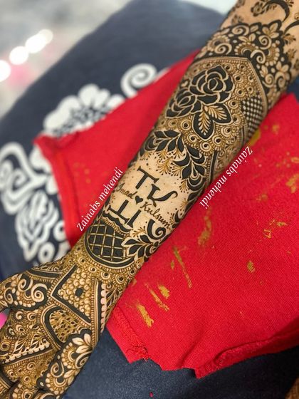 The full arm design for Kulsum, with the couple's initials taking center stage on the forearm.