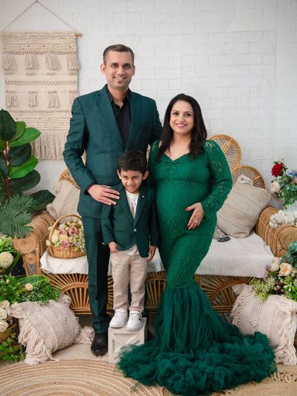 A portrait of elegance and unity. This family chose matching emerald green outfits for their maternity session, creating a sophisticated and cohesive look against our boho-chic backdrop.