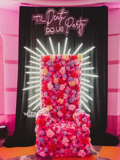 For a couple with a quirky sense of humor, we created this 'Til Death Do Us Party' photo spot. The floral throne and neon sign perfectly matched the vibe of their after-party.