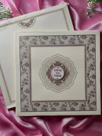 The full view of this classic invitation. The central emblem is framed by a delicate floral border, all set on a beautiful ivory paper with a subtle pattern.