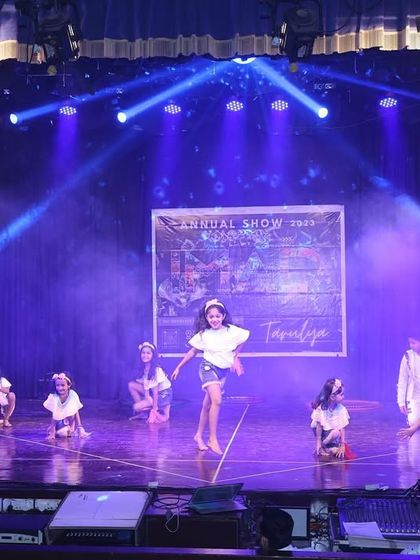 The stage is bathed in blue light as our junior performers execute their routine with grace.