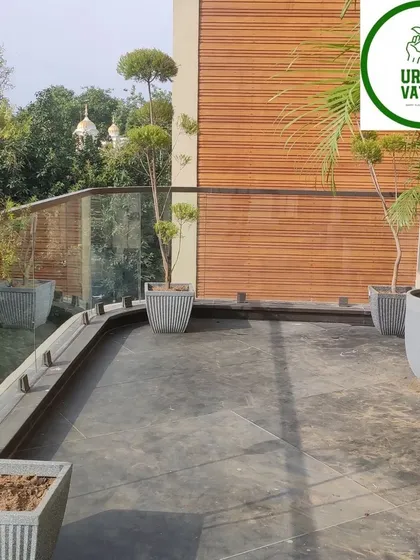 This balcony design uses minimalist square planters to complement the modern architecture. The slender topiary trees add height and structure without blocking the view, creating a clean and elegant outdoor space.