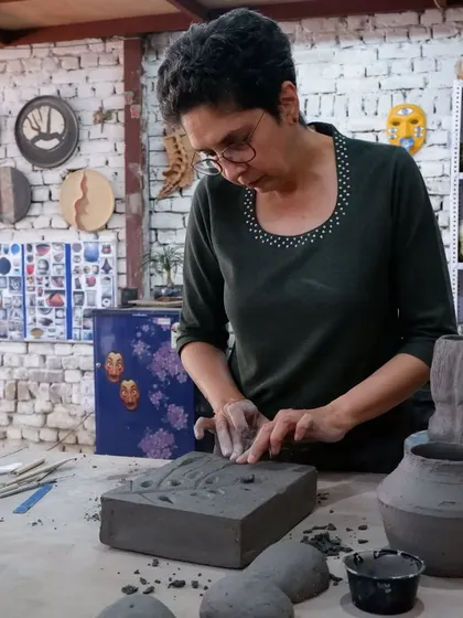 A student carefully works on a textured slab piece. Hand-building is perfect for creating intricate surfaces and geometric forms that are difficult to achieve on the wheel.