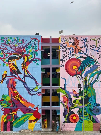A vibrant, multi-story mural for the St+art Kovai festival. This piece explores our relationship with nature in a digital age, with two facades representing a symbiotic harmony between humanized trees and the surrounding flora and fauna.
