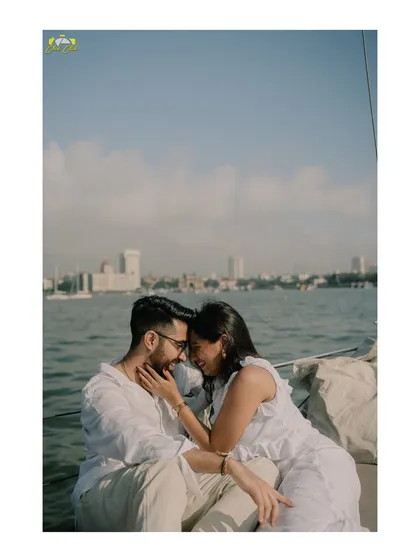 A quiet, intimate moment on the water. The Mumbai cityscape provides a stunning backdrop, but their connection is the real focus.