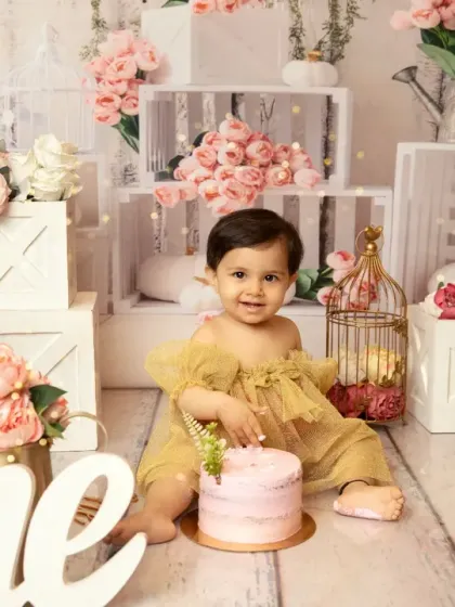 A classic and elegant first birthday setup. Before the smashing begins, I always capture a beautiful portrait with the cake, showcasing the floral theme and the big "One" sign.