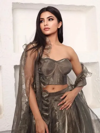 A model in a metallic grey-brown organza lehenga with a modern corset-style blouse.