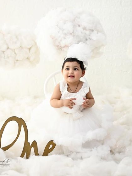 An angel in a sea of clouds. This simple, all-white setup is ethereal and timeless, focusing on the baby's sweet and curious expression.