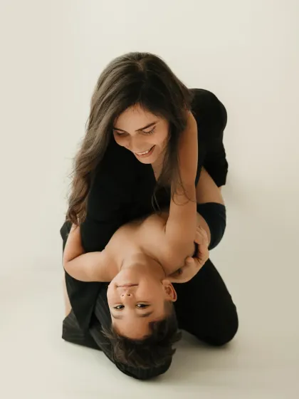 A playful moment with a mother holding her son upside down. This fun pose brings out genuine laughter and joy.