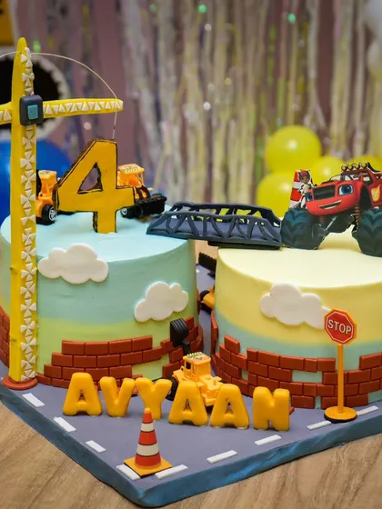 An incredible construction-themed cake, complete with edible roads, signs, a crane, and a monster truck. It's a work of art!