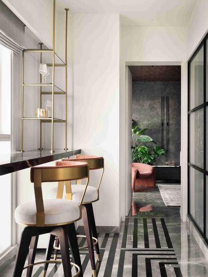 A sleek bar area with brass-accented stools and geometric marble flooring provides a stylish space for entertaining.